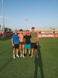 four men posing for a picture on a soccer field