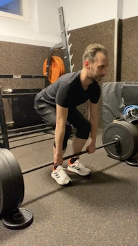 a man squatting with a barbell in a gym