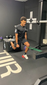 a man squatting on a box in a gym