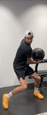 a man holding a ball in a gym