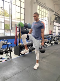 a man standing in a gym with weights